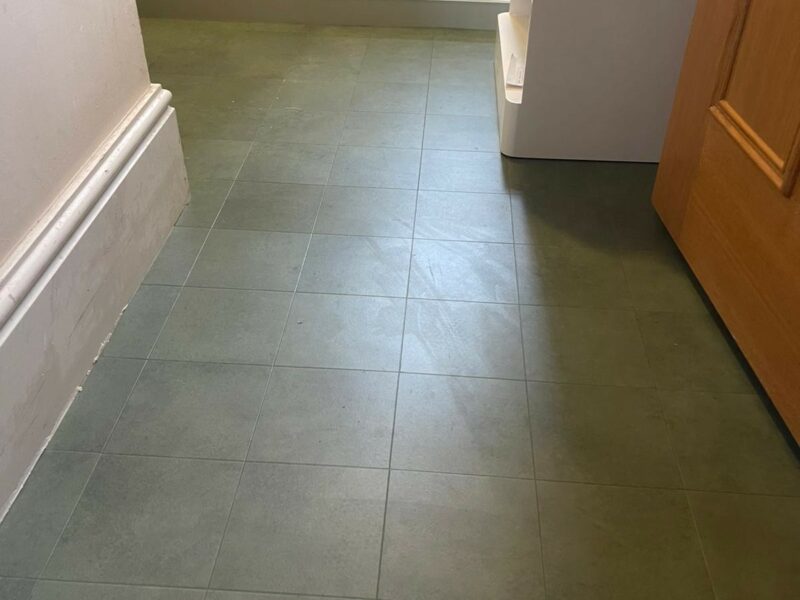Looking into a small bathroom with Amtico Signature Encaustic Okra 152mm x 152mm tile in a marbled green effect